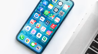 Smartphone on a dark reflective surface representing Apple's upcoming iPhone Fold 2026 foldable device entering trial production with 7.8 inch display and $2000 price point