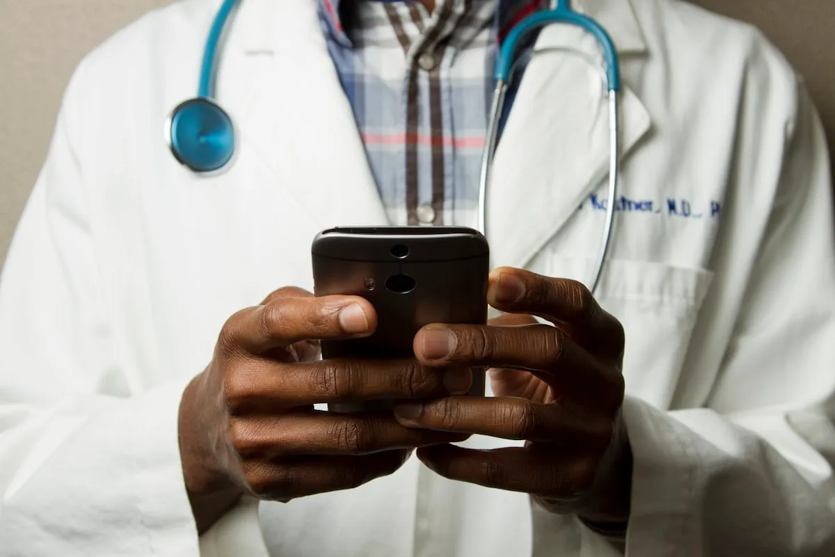 A person's hand holding a smartphone displaying a health-related AI interface, with a stethoscope in the background, representing the intersection of digital wellness and medical technology.
