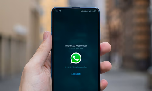 WhatsApp logo on a smartphone with a security alert icon