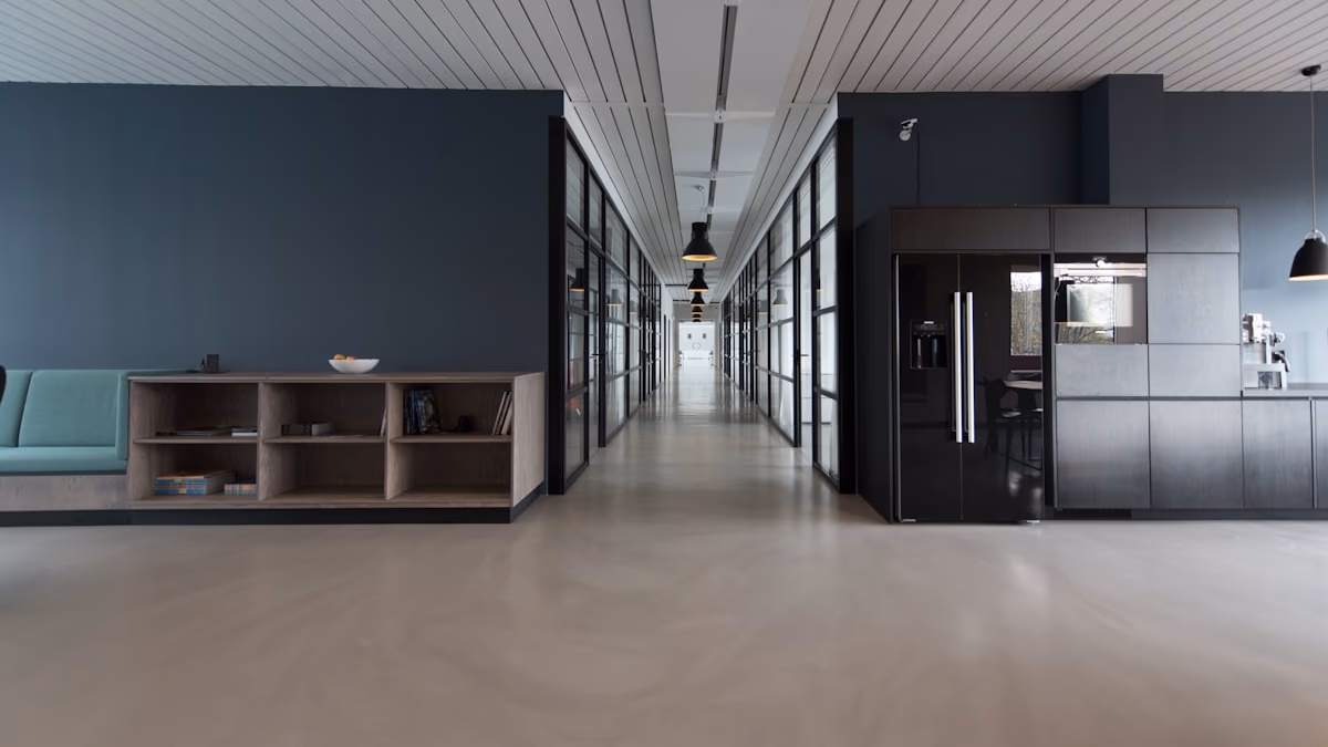 A wide open-plan corporate office with empty modern workstations, ergonomic chairs, and large windows letting in afternoon light — representing the changing landscape of tech employment as Microsoft offers voluntary retirement buyouts to 8,750 experienced US workers while simultaneously reporting record-breaking AI-driven revenue growth.