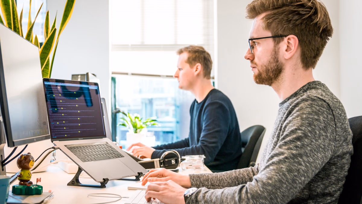 Office employees on computers representing Meta's Claudeonomics internal AI token usage leaderboard competition in 2026