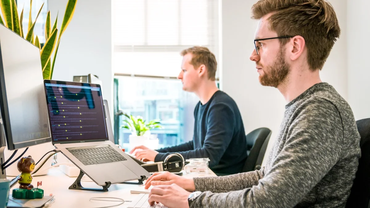 Office employees on computers representing Meta's Claudeonomics internal AI token usage leaderboard competition in 2026