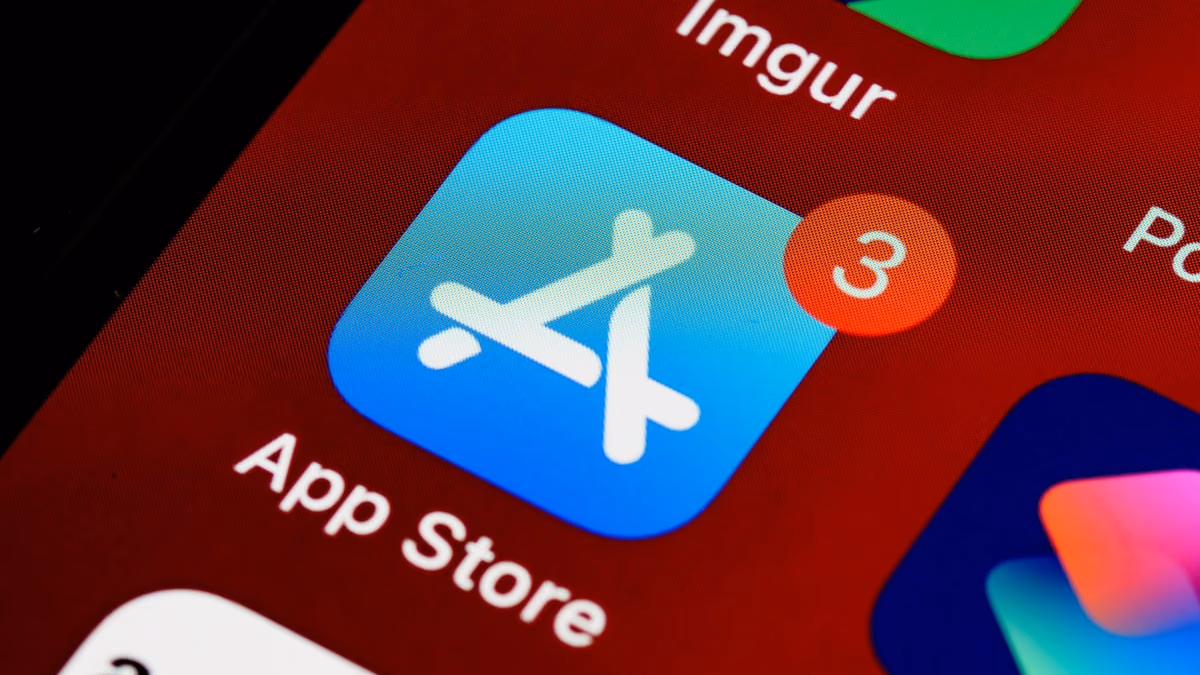 Smartphone showing the App Store with a blurred Apple logo in the background
