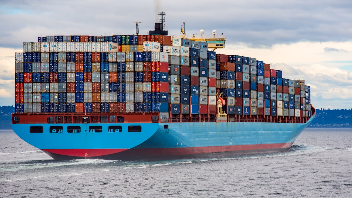 Terminal showing docker compose up -d output with four containers starting — web, api, postgres, redis — and docker compose ps showing all containers healthy with port mappings on Ubuntu 24.04.
