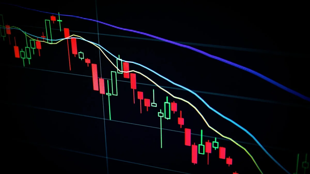 Stock market data on a screen with AI company logos, representing the SoftBank OpenAI investment and IPO speculation